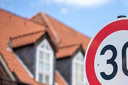 Ein Verkehrsschild, das Tempo 30 anzeigt, an einer Straße