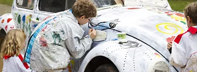 Kinder bemalen eine Auto